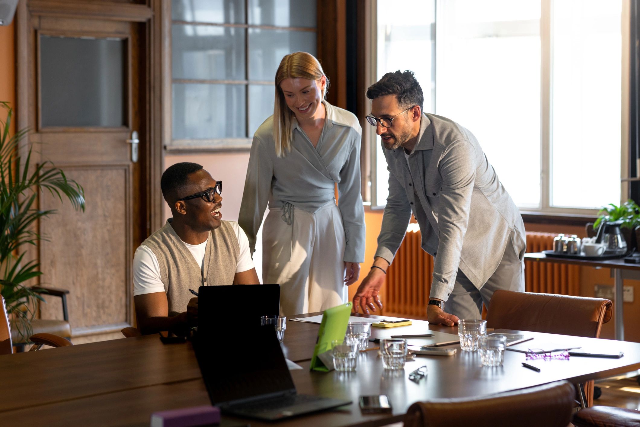 Professionals collaborating around a laptop